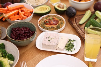 Healthy vegetarian food and glass of juice on wooden table