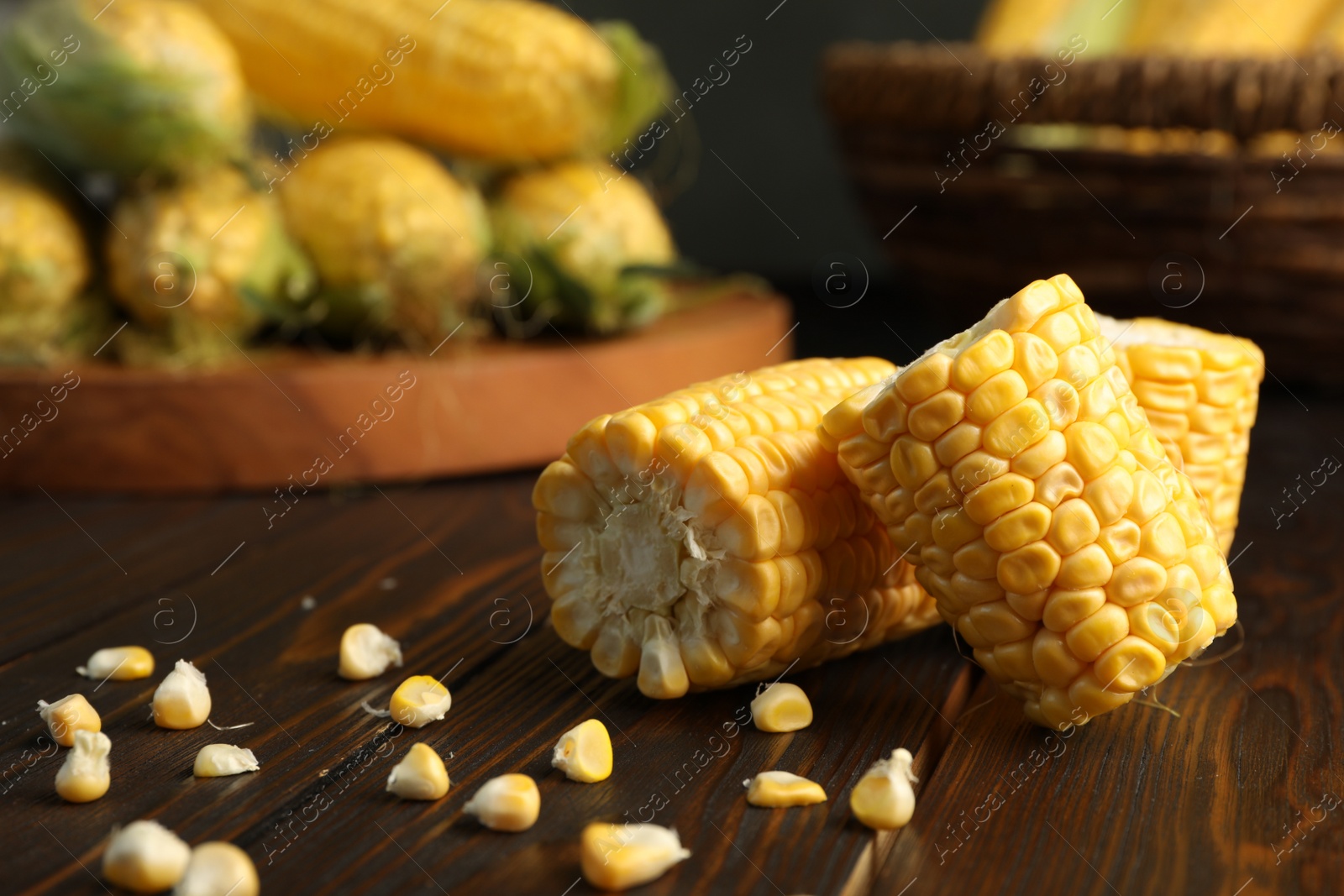 Photo of Tasty sweet corn cobs on wooden table, closeup