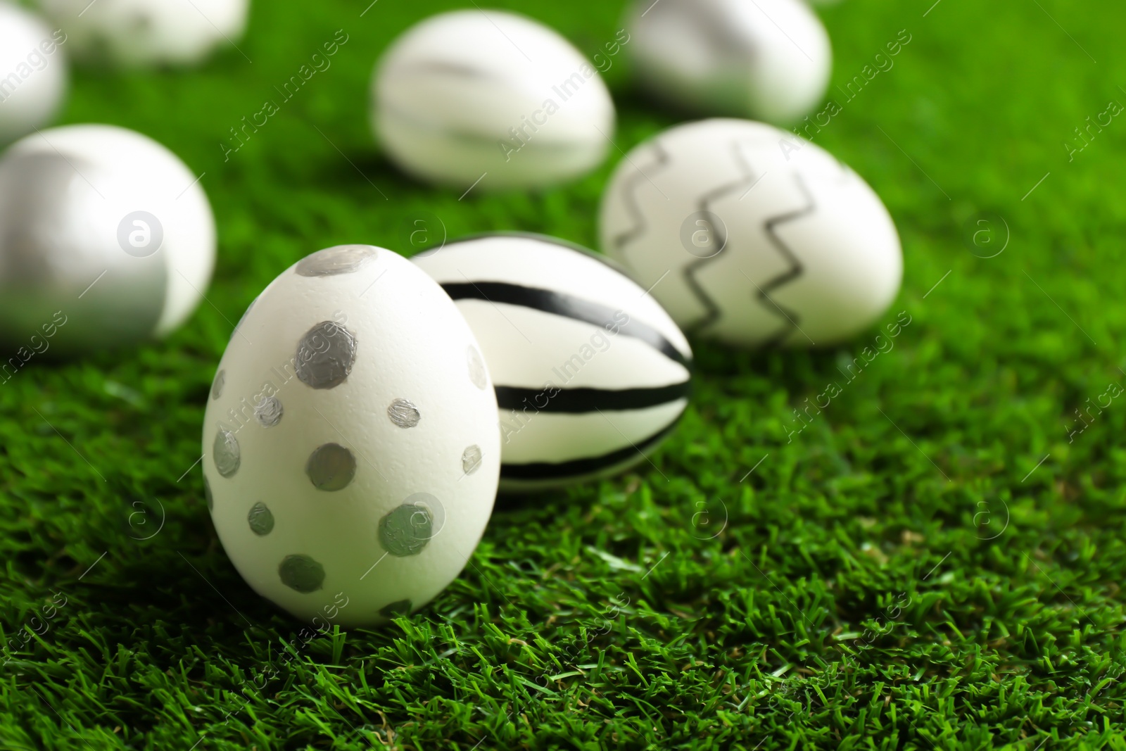 Photo of Traditional painted Easter eggs on green lawn, closeup