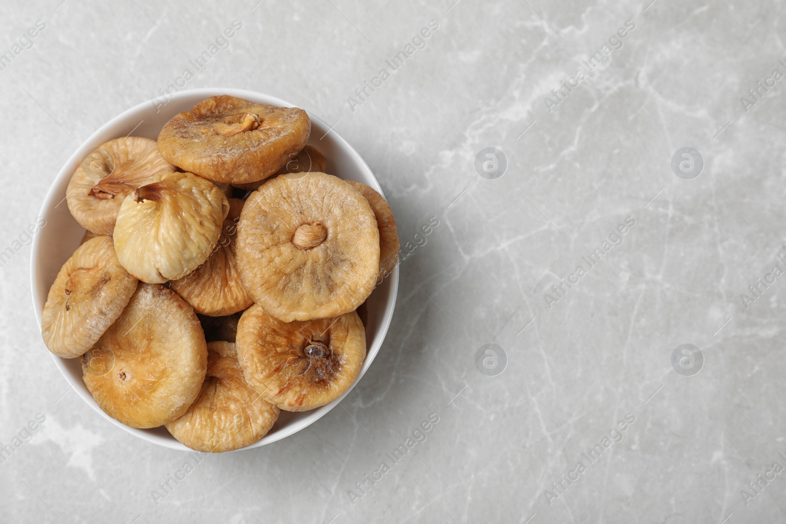 Photo of Tasty dried figs on light grey table, top view. Space for text