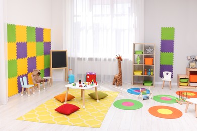 Photo of Child`s playroom with different toys and furniture. Cozy kindergarten interior