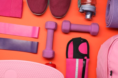 Different sports equipment on orange background, flat lay