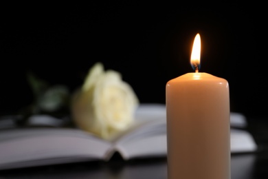 Photo of Burning candle on blurred background, space for text. Funeral symbol