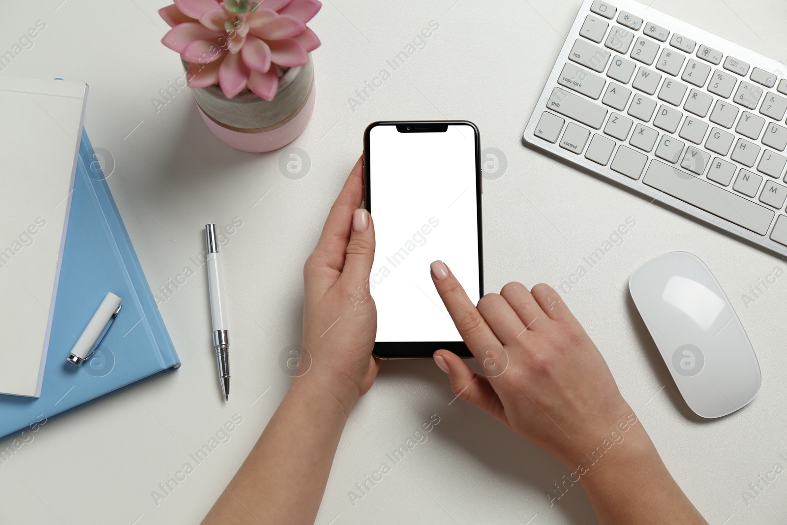 Photo of Woman using smartphone at white table, top view