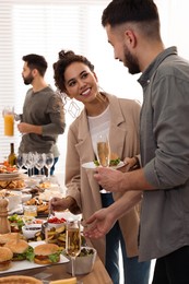 Photo of Young couple enjoying brunch buffet together indoors
