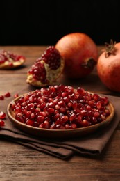 Ripe juicy pomegranates and grains on wooden table