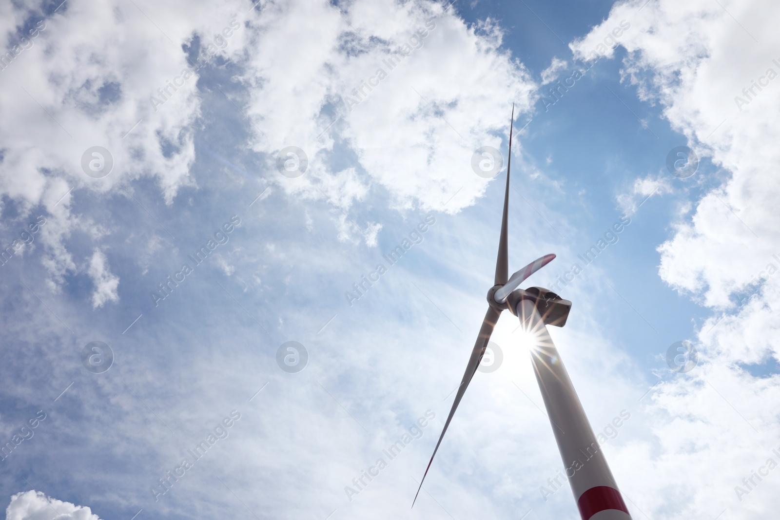 Photo of Modern wind turbine against cloudy sky, low angle view. Alternative energy source