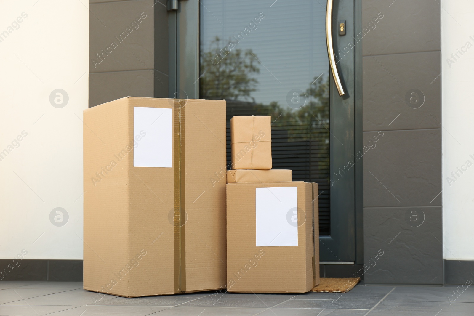 Photo of Cardboard boxes near door. Parcel delivery service