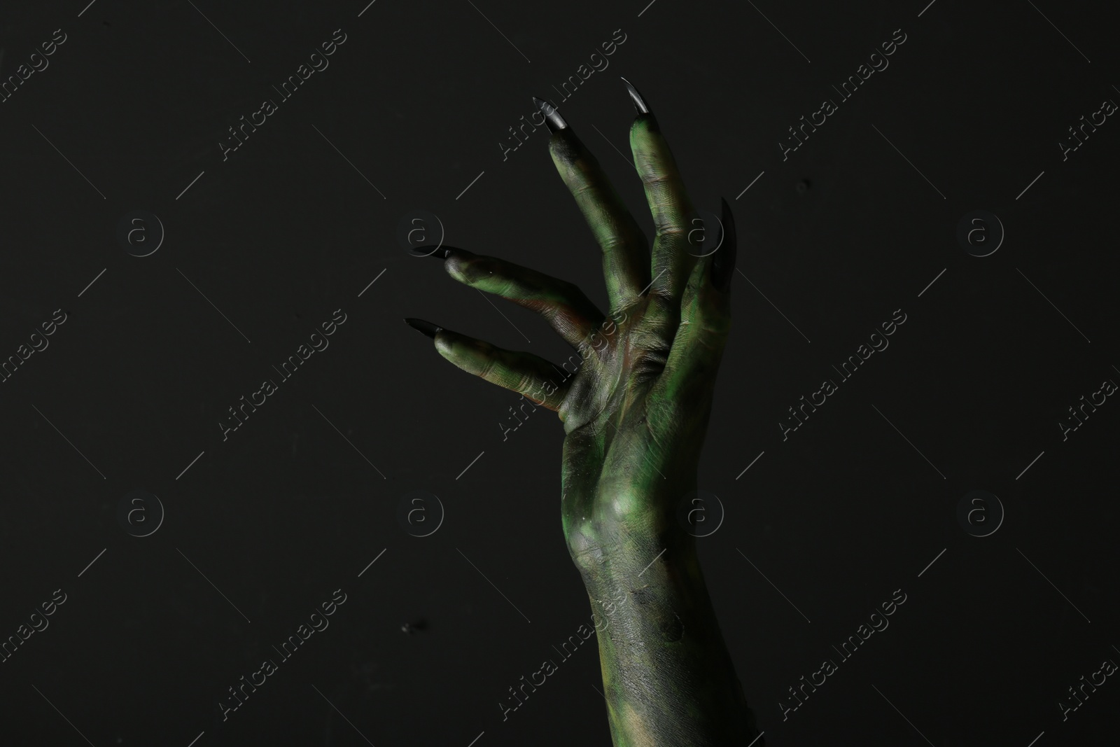 Photo of Scary monster on black background, closeup of hand. Halloween character