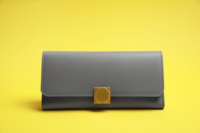 Photo of Stylish light grey leather purse on yellow background