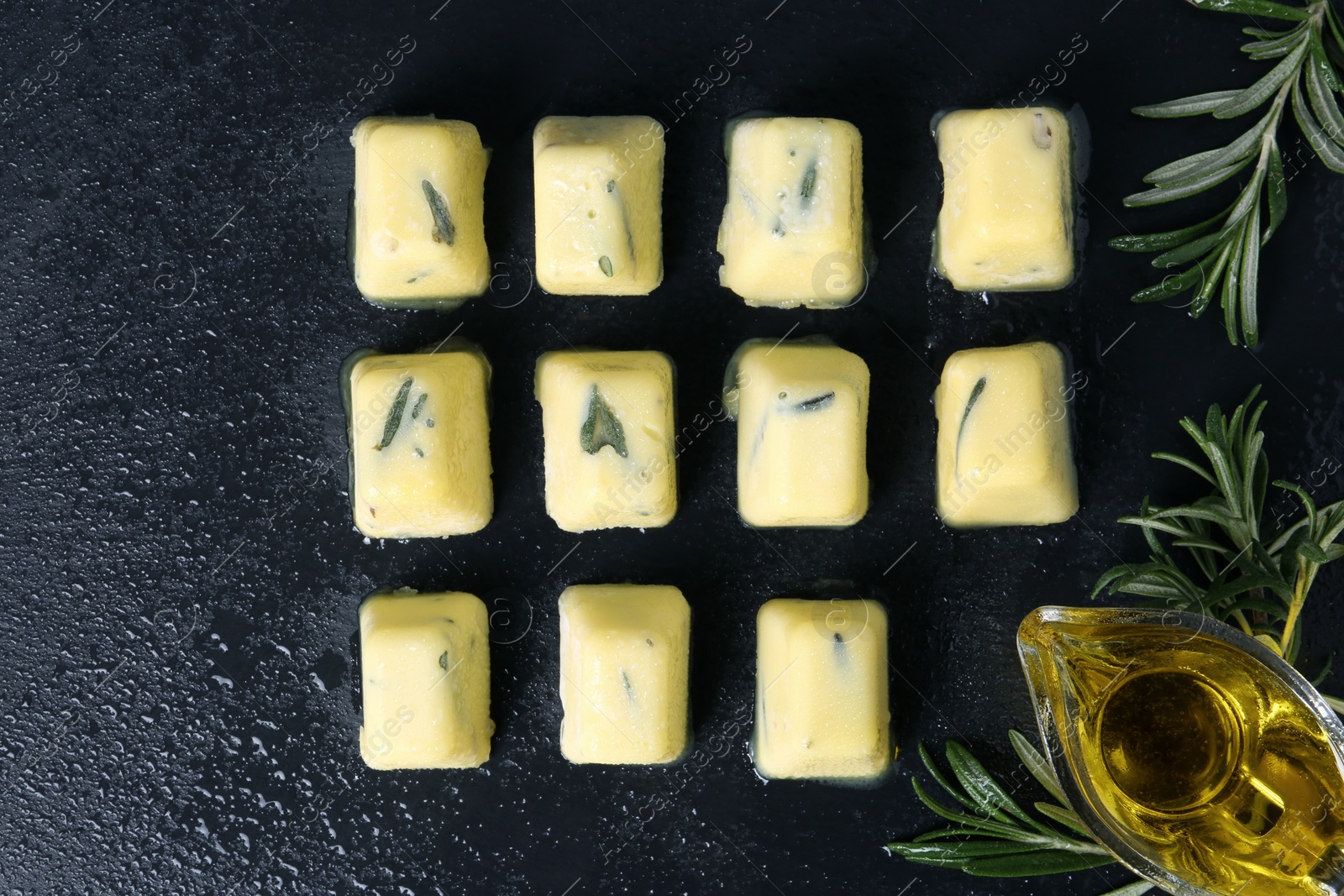 Photo of Flat lay composition with rosemary and olive oil ice cubes on dark background