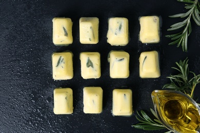 Flat lay composition with rosemary and olive oil ice cubes on dark background