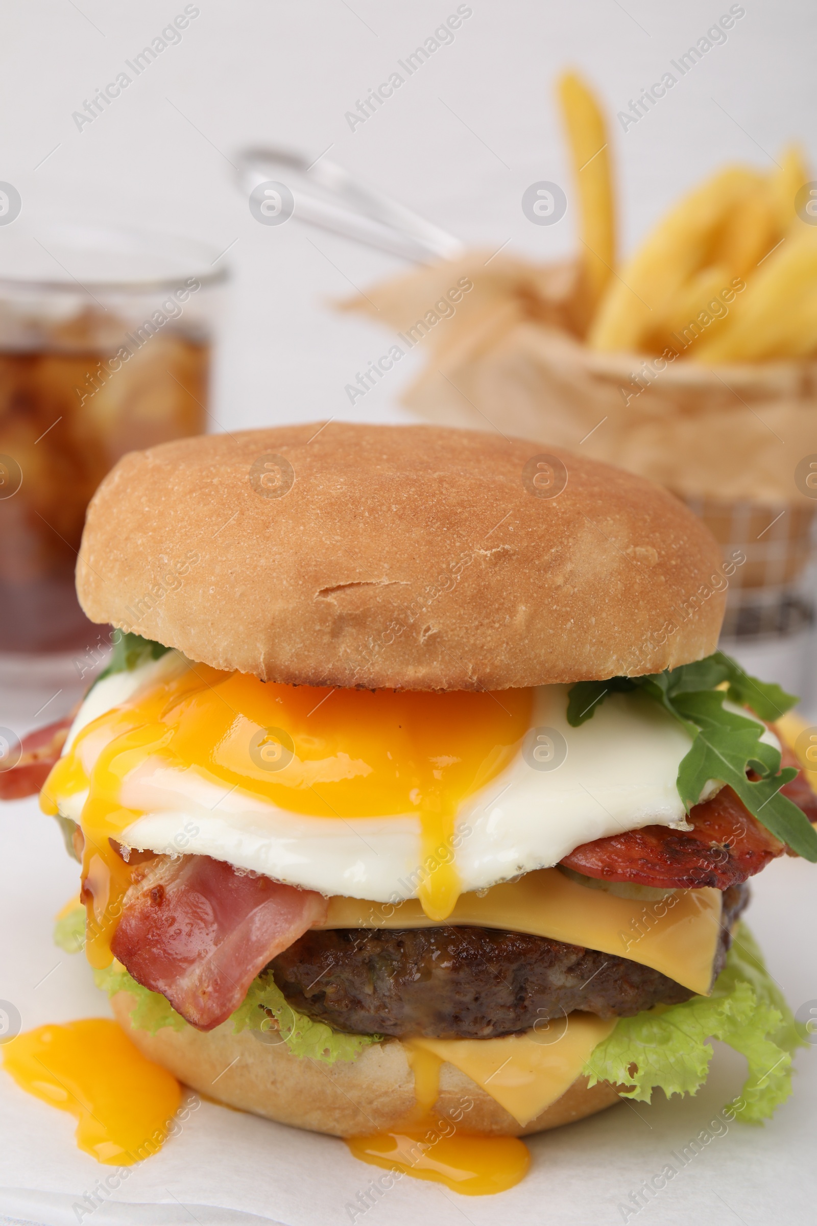 Photo of Delicious burger with fried egg on white table, closeup