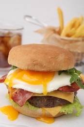 Photo of Delicious burger with fried egg on white table, closeup