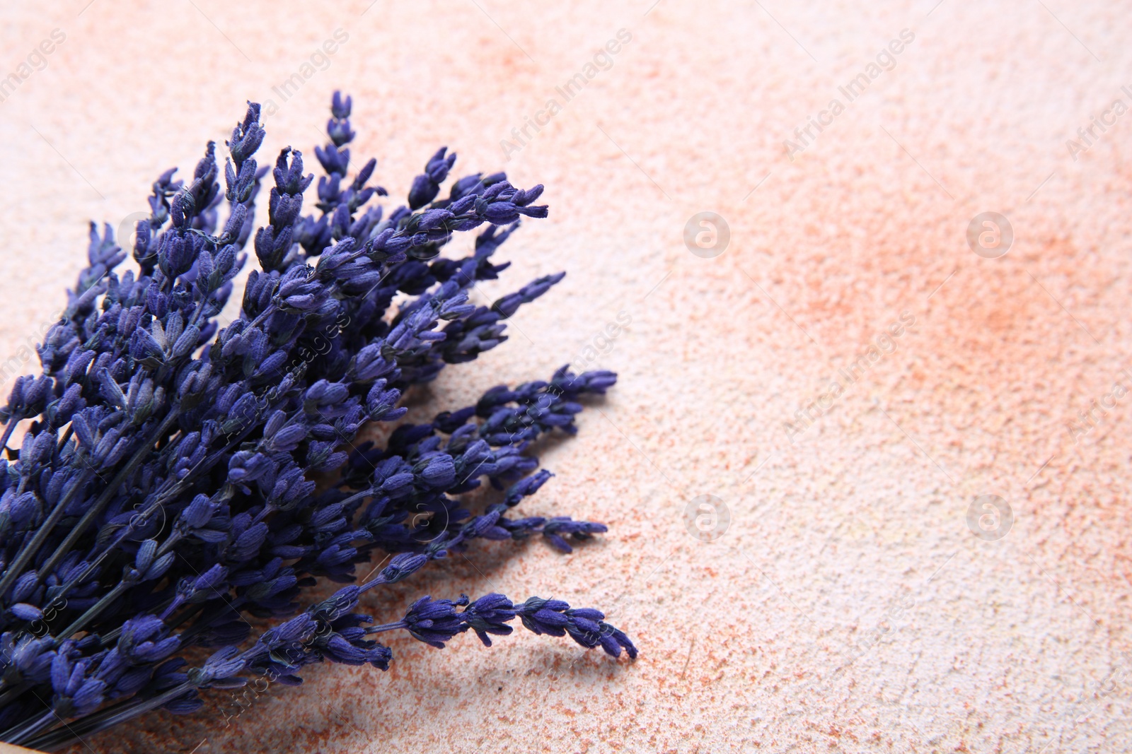 Photo of Bouquet of beautiful preserved lavender flowers on color textured table, closeup. Space for text