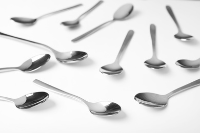 Photo of Set of new metal spoons on white background