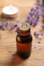 Photo of Bottle of essential oil and lavender flowers on wooden table