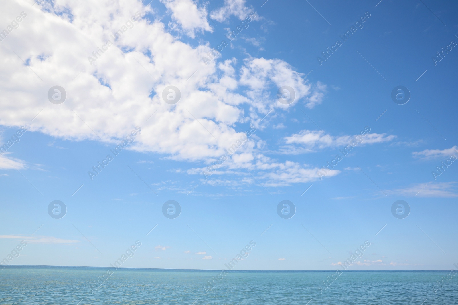 Photo of Picturesque view of sea under beautiful blue sky with fluffy clouds