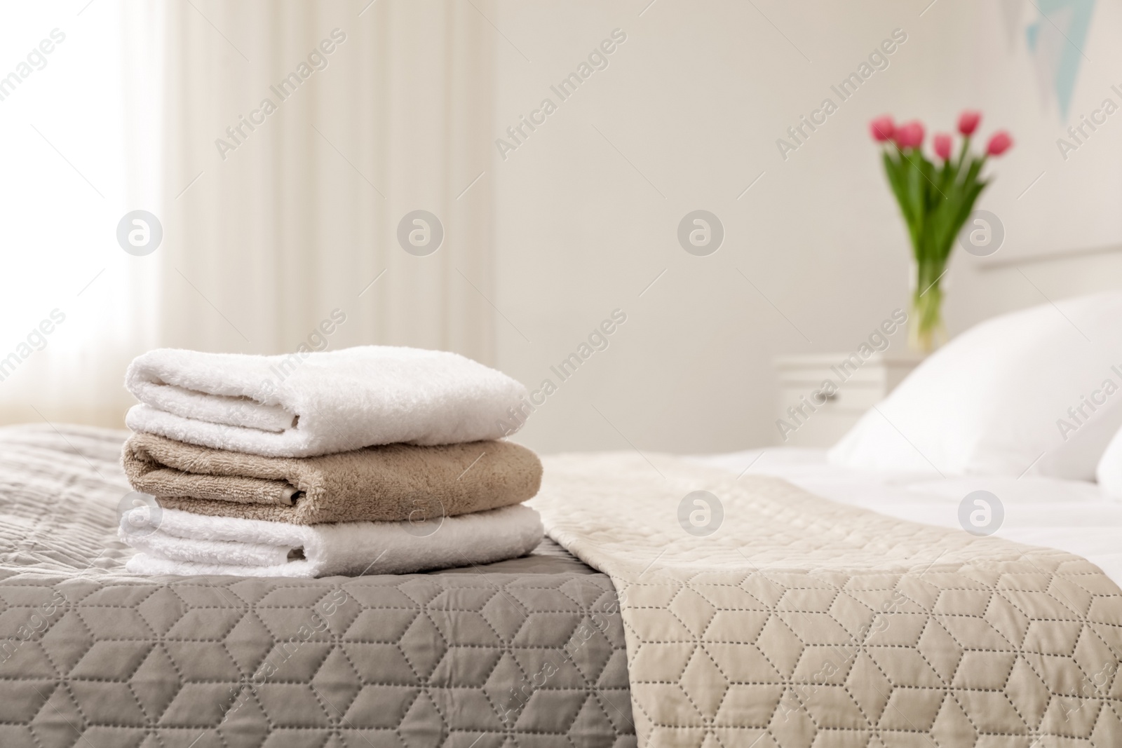 Photo of Soft bath towels on bed in hotel suite, space for text