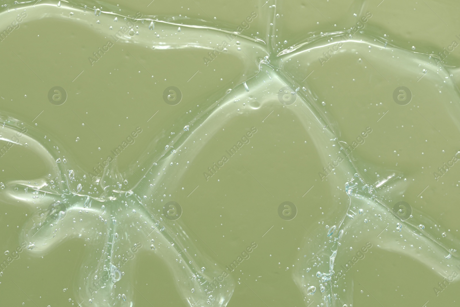 Photo of Transparent cleansing gel on green background, closeup. Cosmetic product