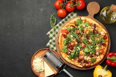 Delicious vegetarian pizza, ingredients and grater on black table, flat lay. Space for text