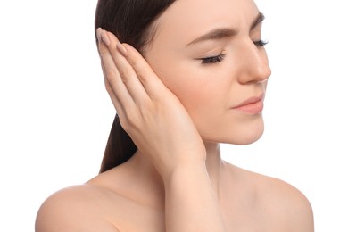 Young woman suffering from ear pain on white background, closeup