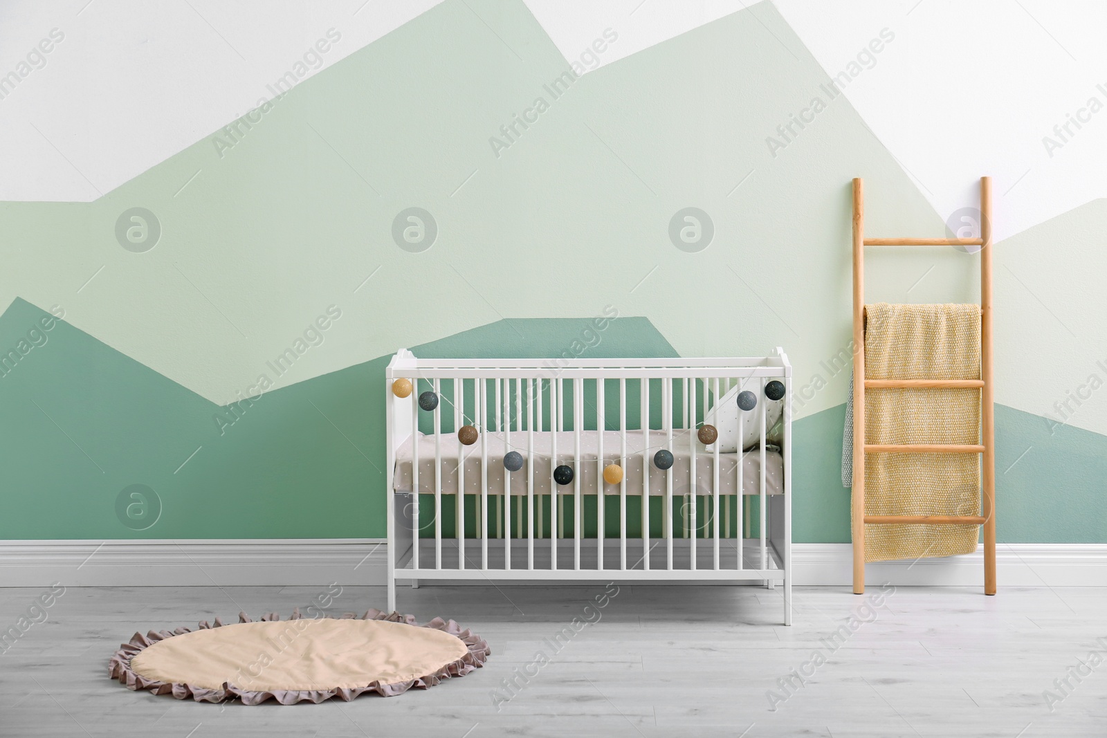 Photo of Baby room interior with crib near wall