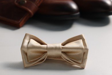 Photo of Stylish pale yellow bow tie on white table