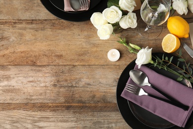Elegant festive table setting on wooden background, flat lay. Space for text