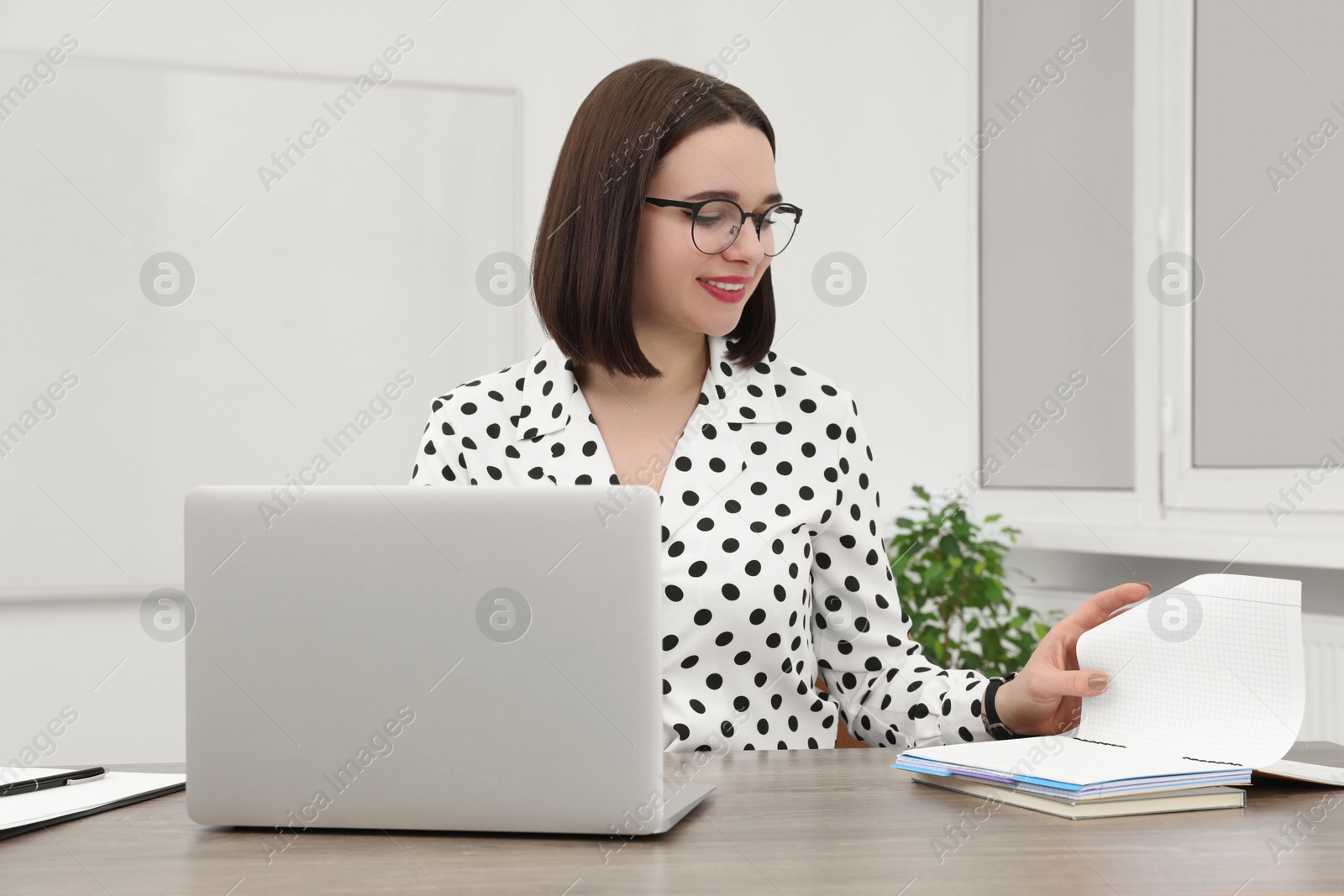 Photo of Happy young intern working at table in modern office