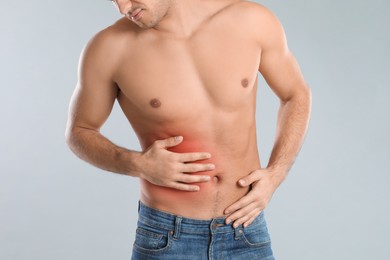 Photo of Man suffering from liver pain on grey background, closeup