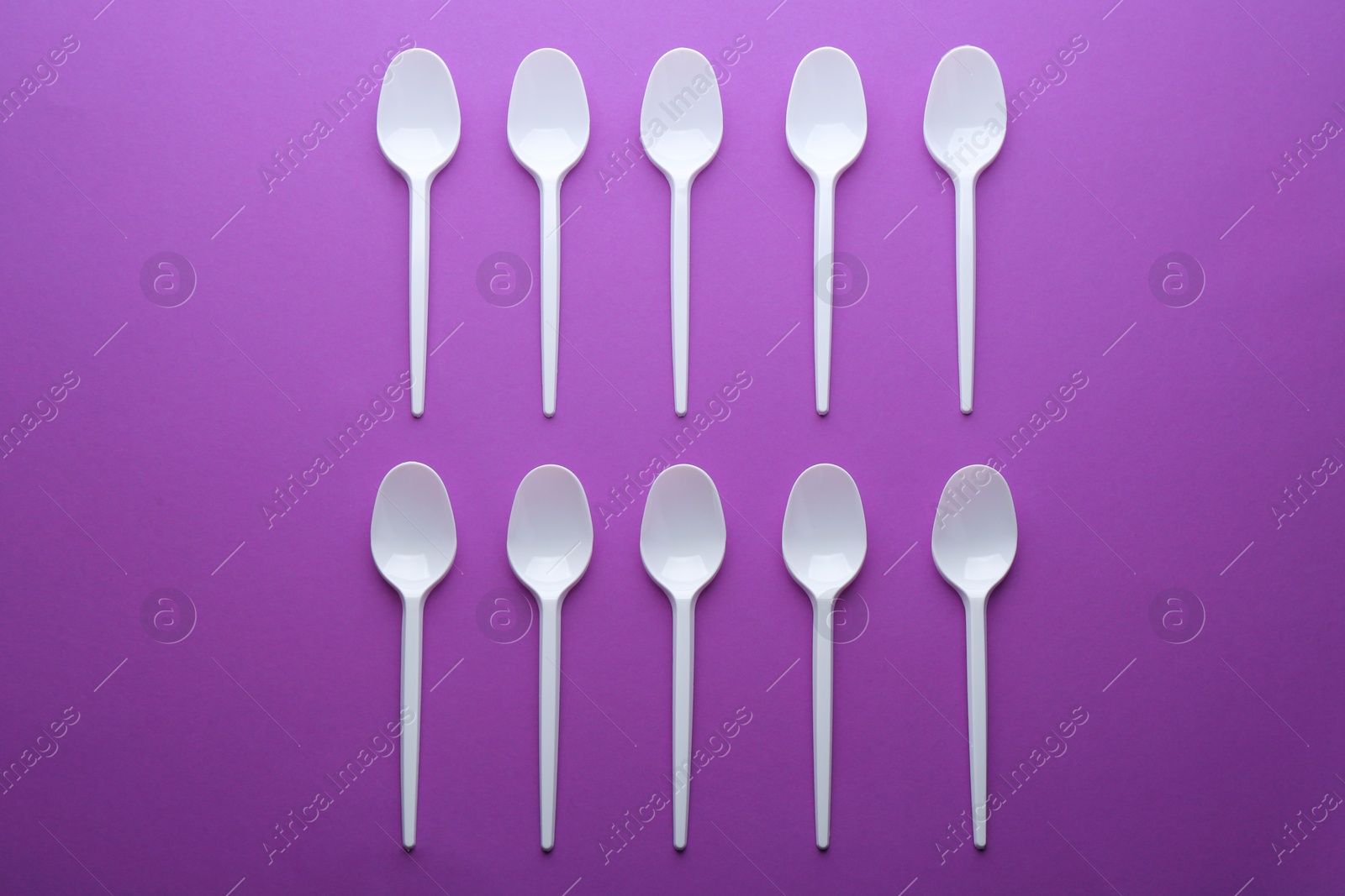 Photo of Plastic spoons on color background, top view. Picnic table setting