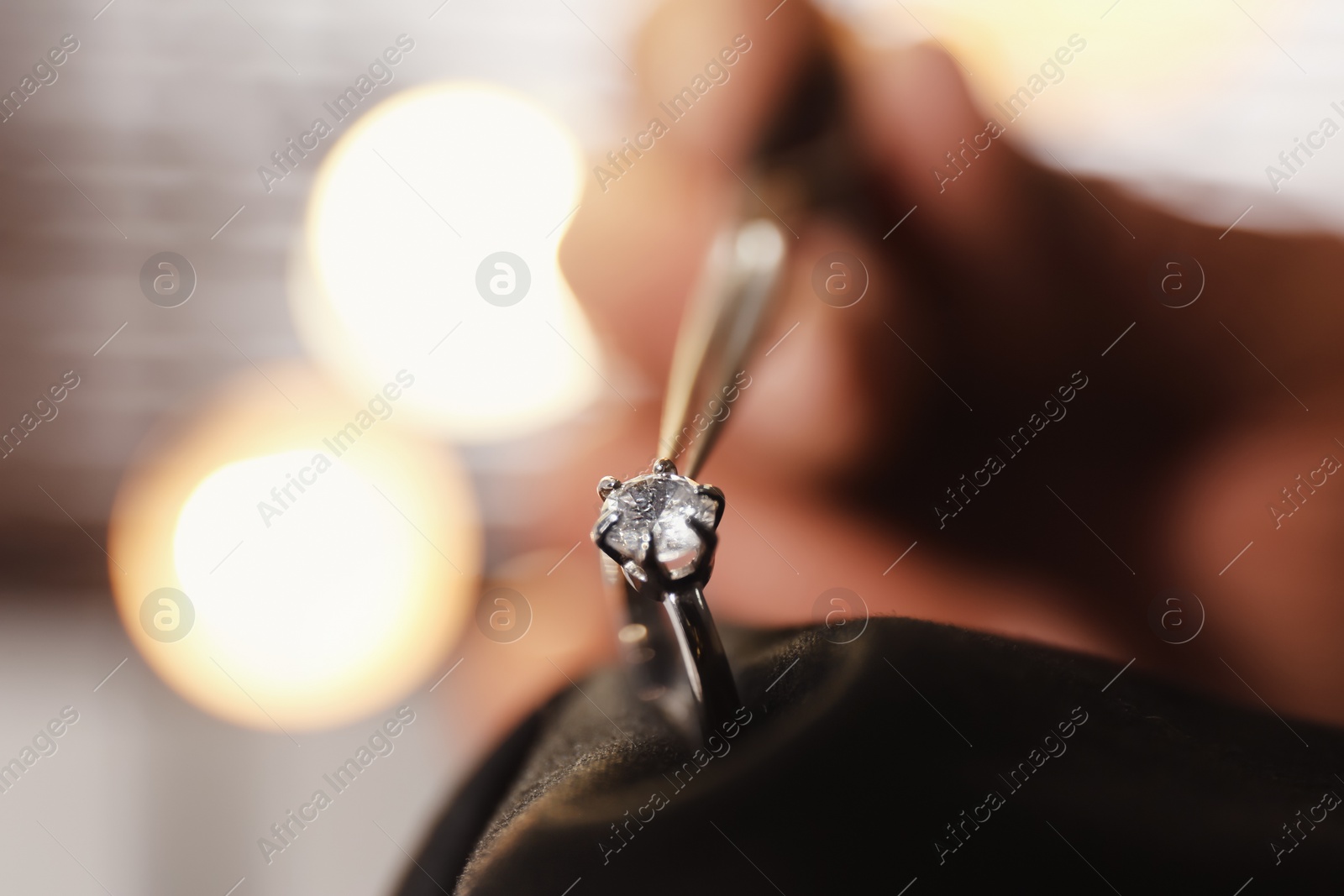 Photo of Professional jeweler working with beautiful ring indoors, closeup