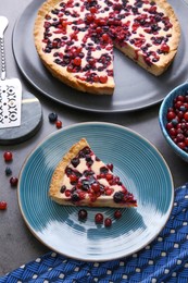 Delicious currant pie and fresh berries on grey table, above view