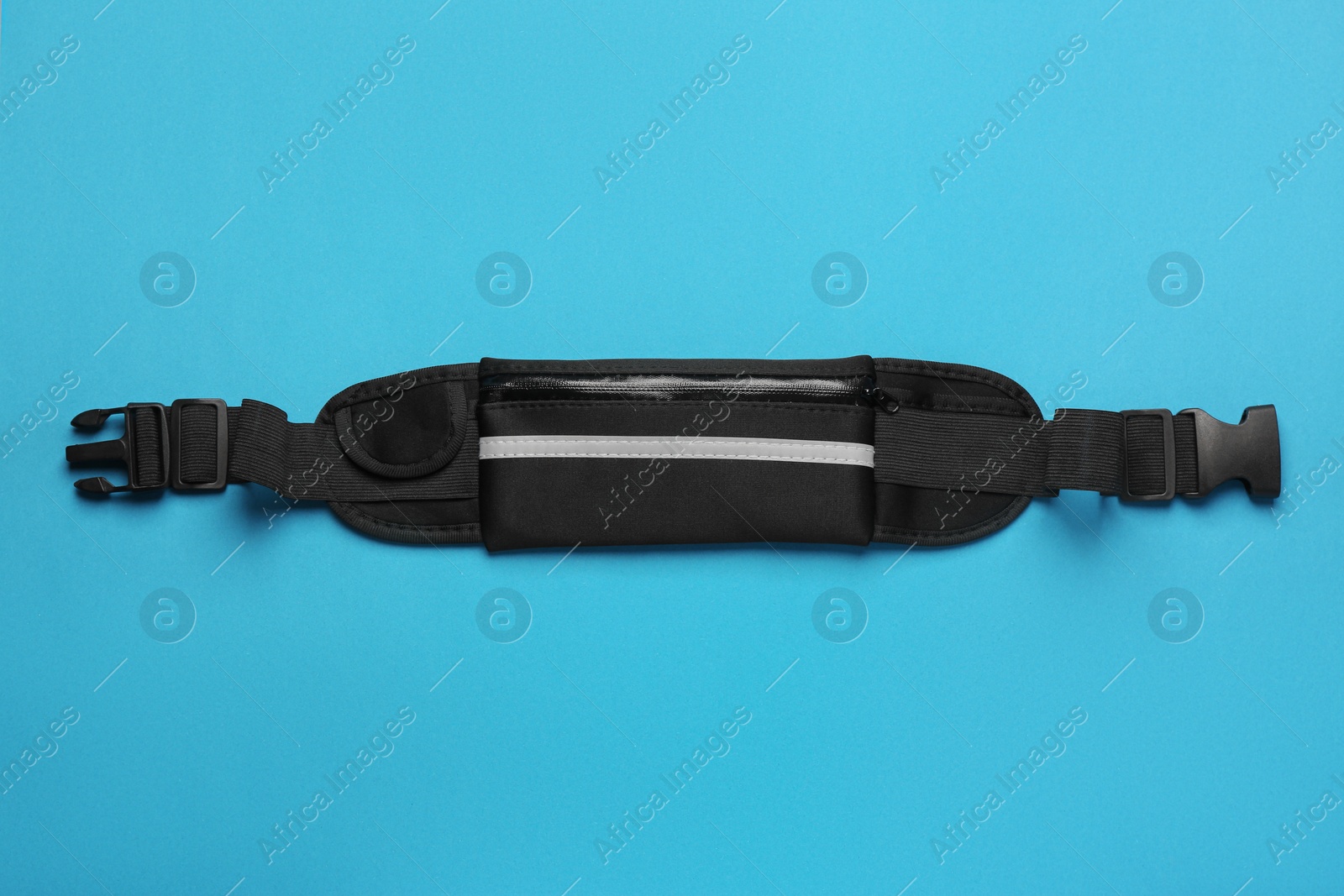 Photo of Stylish black waist bag on light blue background, top view