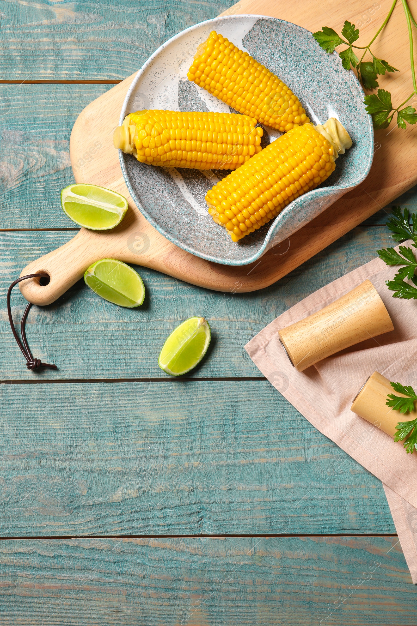 Photo of Flat lay composition with corn cobs on wooden background with space for text