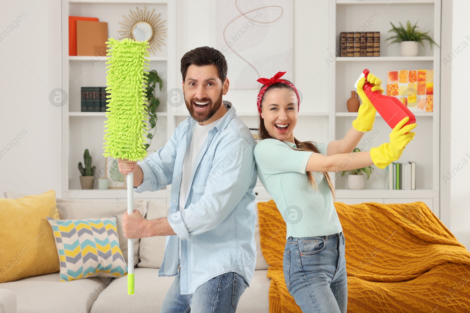 Photo of Spring cleaning. Couple with spray and mop in living room