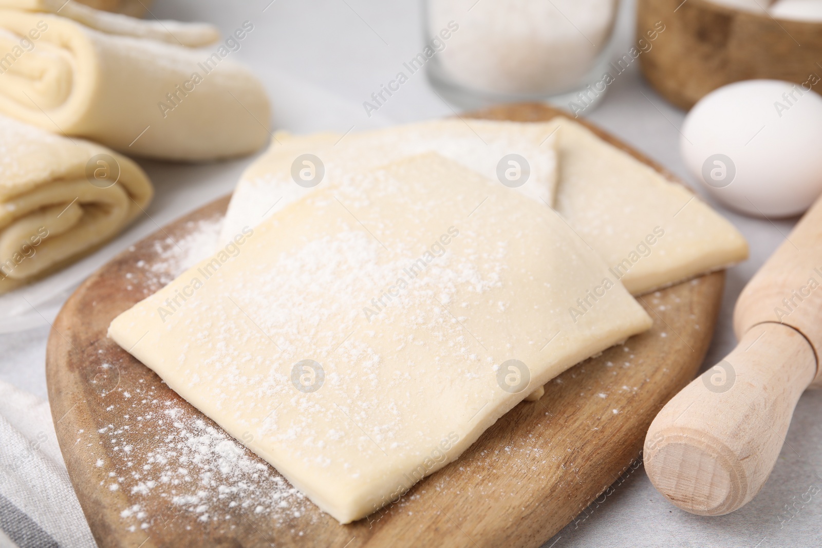 Photo of Raw puff pastry dough on table, closeup