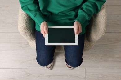 Photo of Man working with tablet in armchair, top view