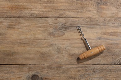 Photo of One corkscrew on wooden table, top view. Space for text