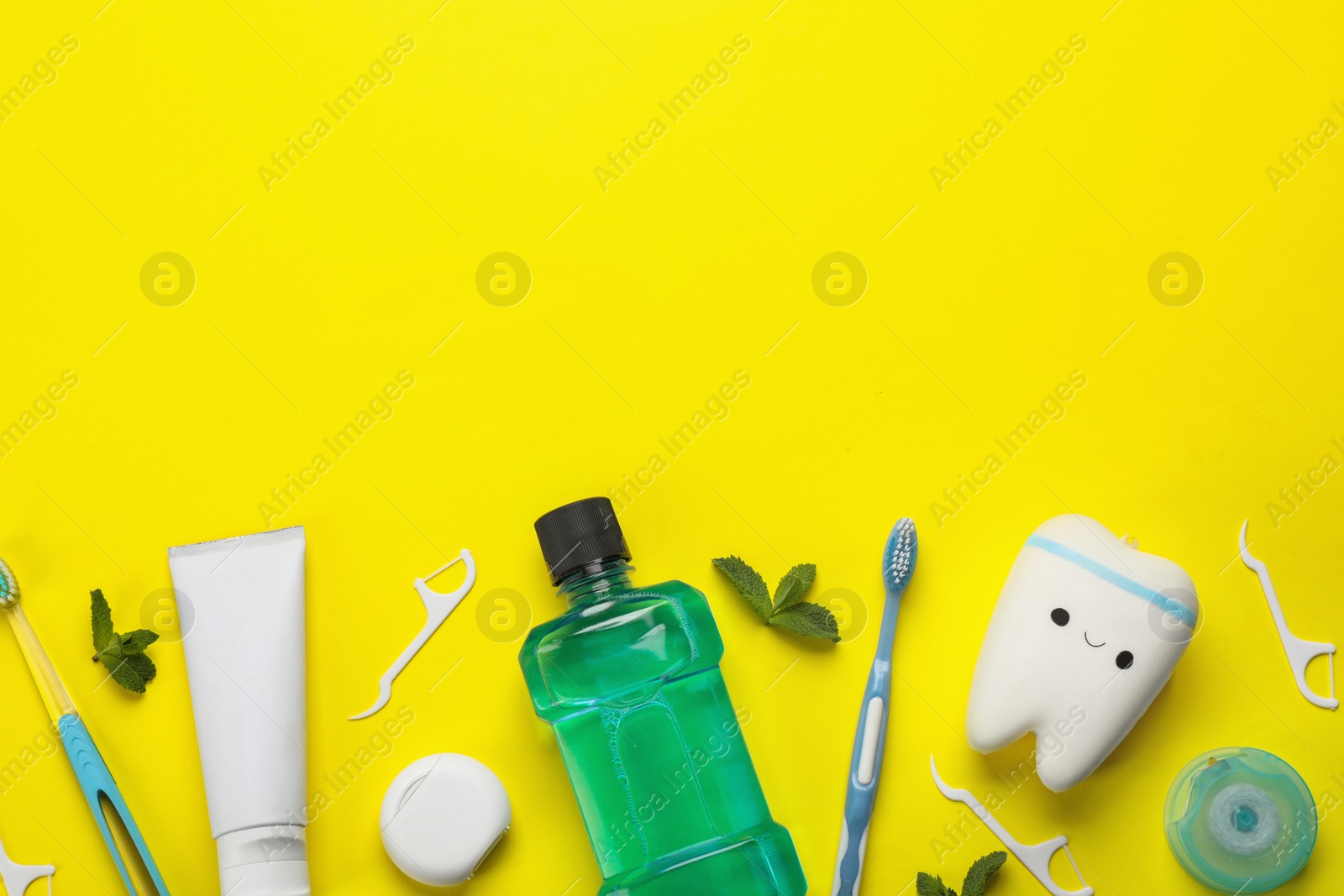 Photo of Flat lay composition with mouthwash and other oral hygiene products on yellow background. Space for text