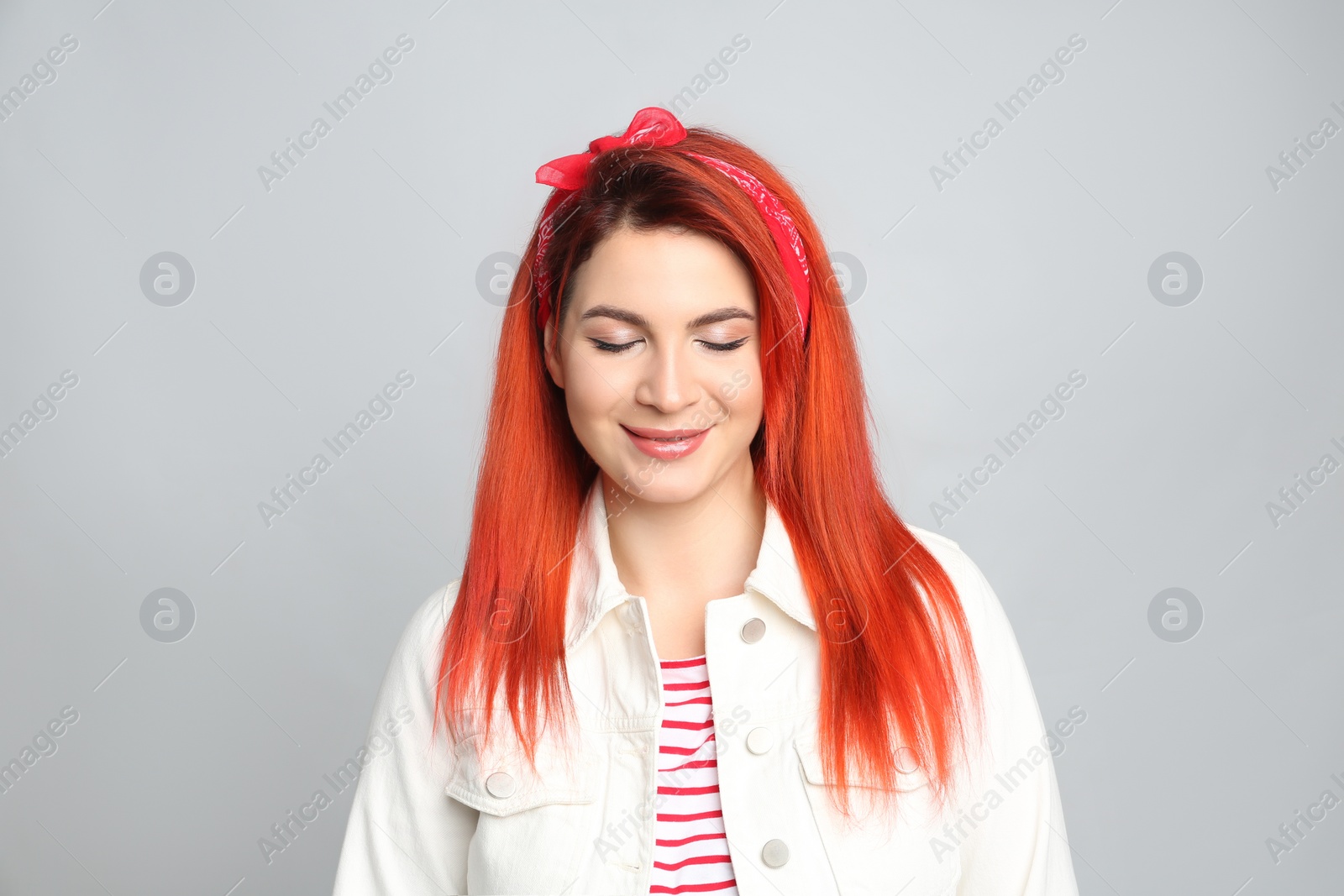 Photo of Young woman with bright dyed hair on grey background