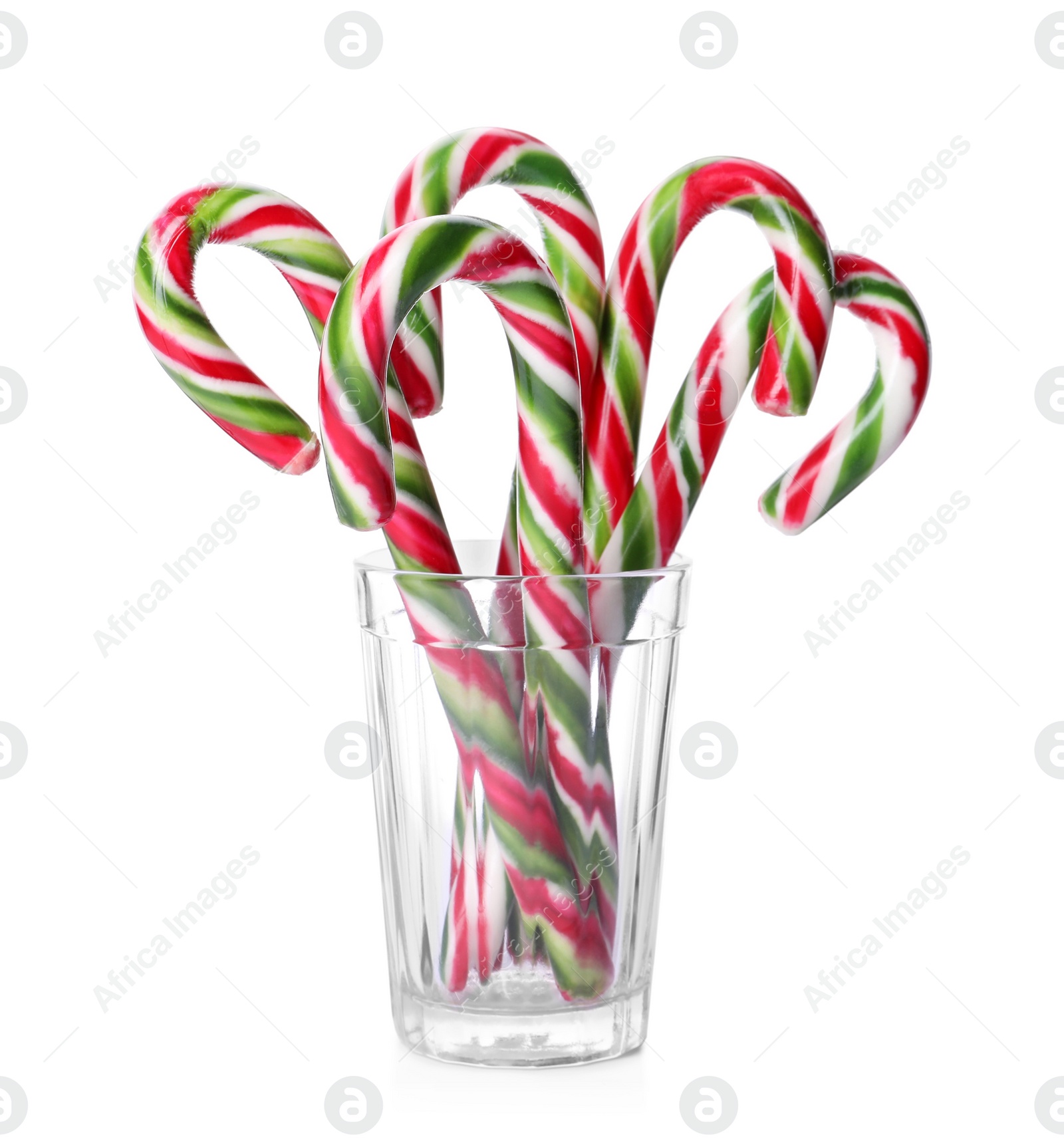 Photo of Sweet Christmas candy canes in glass on white background