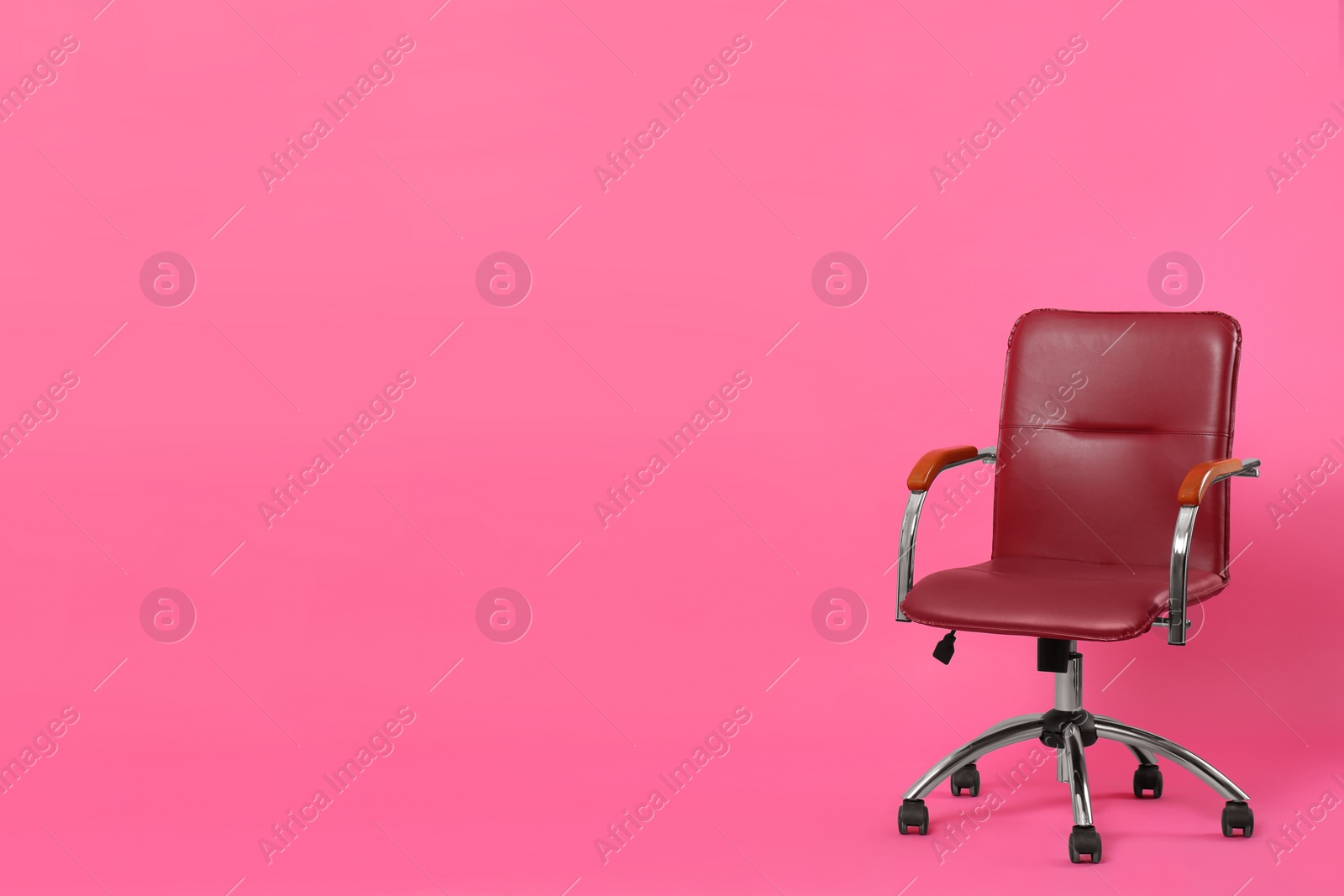 Photo of Comfortable office chair on pink background, space for text