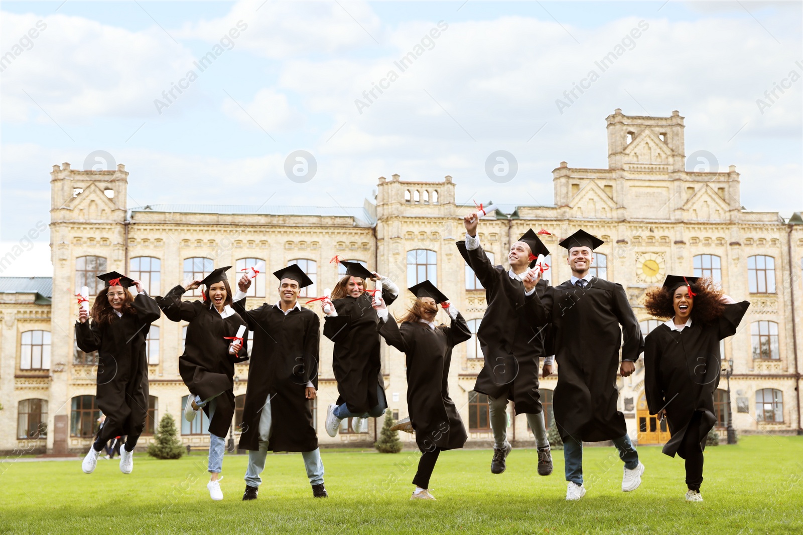 Photo of Happy students with diplomas outdoors. Graduation ceremony