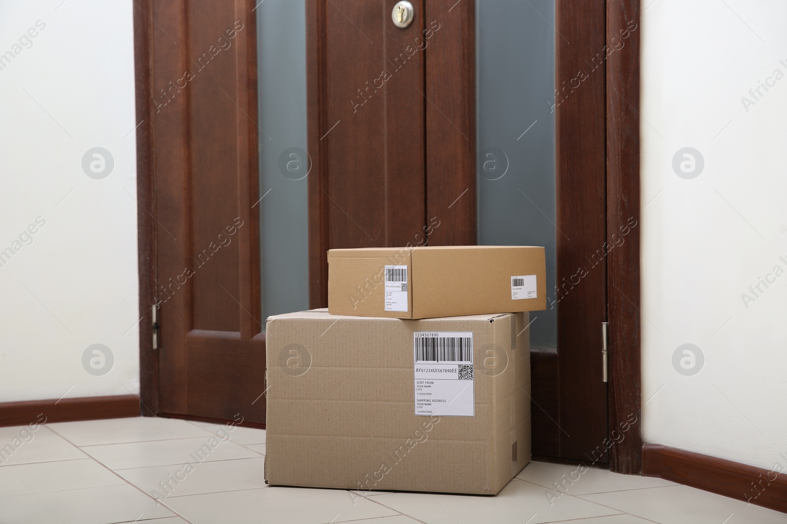 Photo of Stacked parcels near door on floor. Delivery service