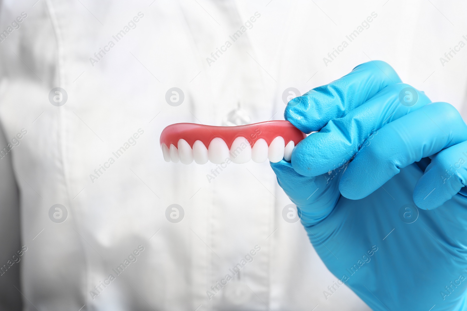 Photo of Dentist holding teeth cover, closeup view. Restorative dentistry