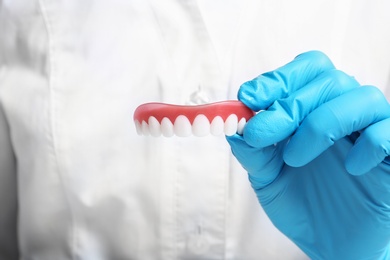 Photo of Dentist holding teeth cover, closeup view. Restorative dentistry