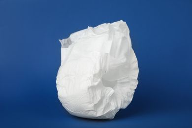 Photo of Disposable diaper on blue background. Child's underwear