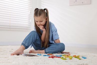 Photo of Motor skills development. Girl playing with colorful wooden arcs indoors